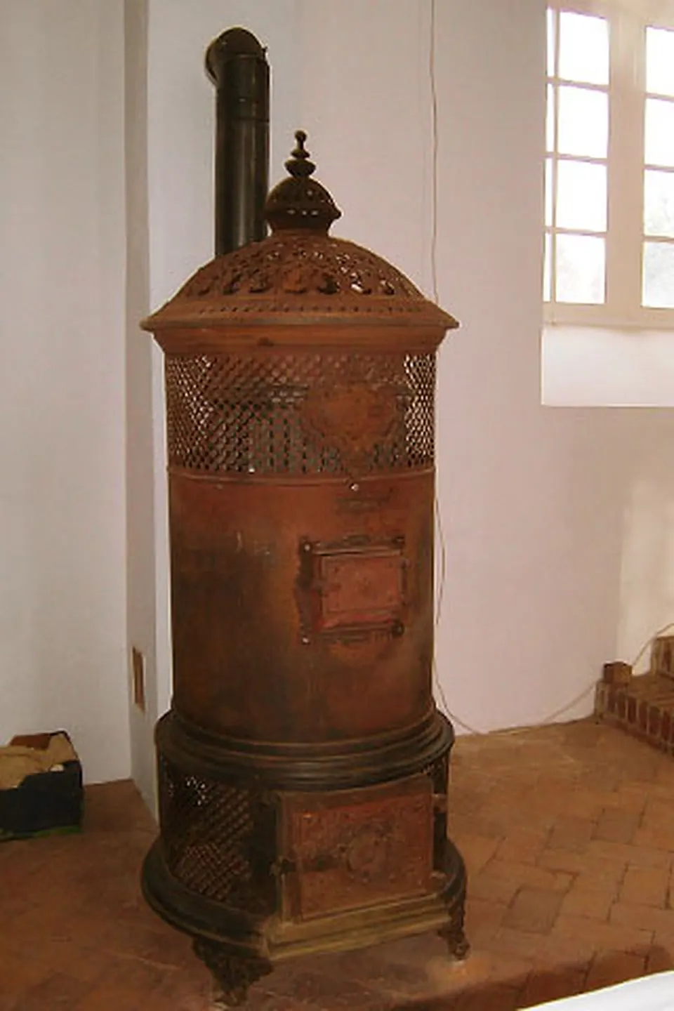 Restaurierter historischer Kachelofen mit dunklen Kacheln